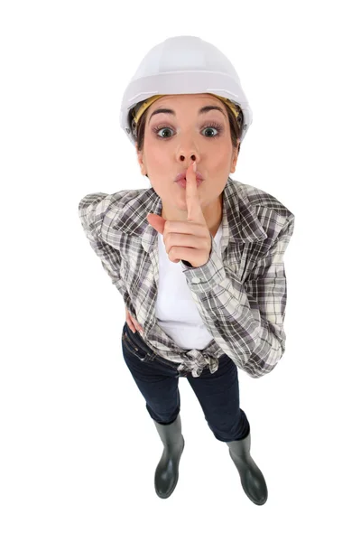 Young craftswoman with finger before mouth to keep a secret — Stock Photo, Image