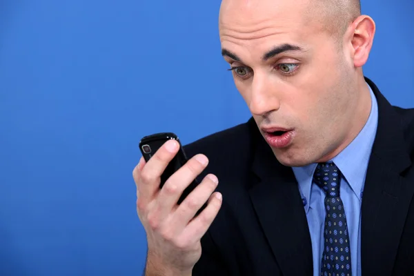 Empresário chocado com telefone móvel — Fotografia de Stock