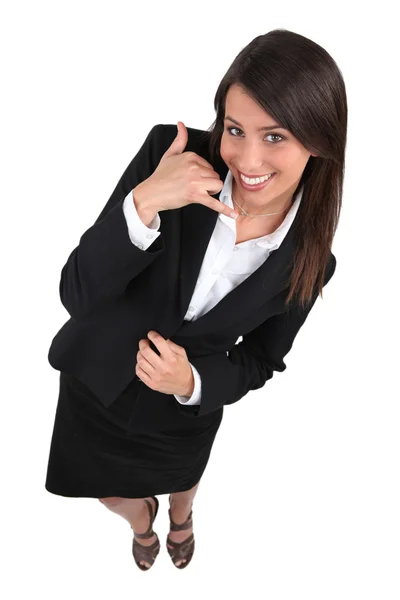 Studioaufnahme einer jungen Geschäftsfrau, die mit der Hand ein Telefonschild macht — Stockfoto