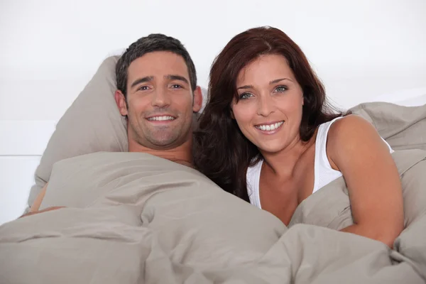 Bir erkek ve kadın yatakta yatan — Stok fotoğraf