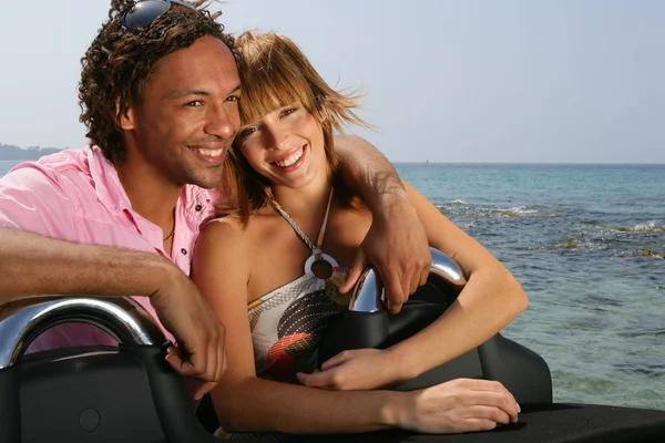 Jeune couple à la plage se tenait en voiture convertible — Photo