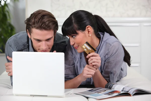Молодой человек и молодая женщина делают онлайн покупки — стоковое фото