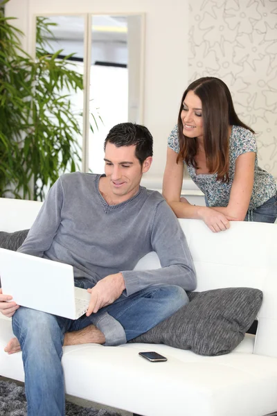 Paar thuis kijken naar een laptop — Stockfoto