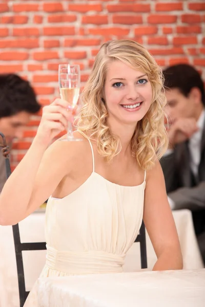 Blonde woman with a glass of white wine — Stock Photo, Image