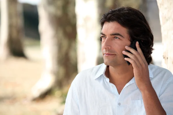 Een man op de telefoon in de natuur — Stockfoto
