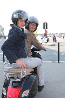 A couple riding a scooter clipart