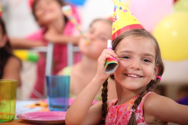 Young girl at a child's birthday party clipart