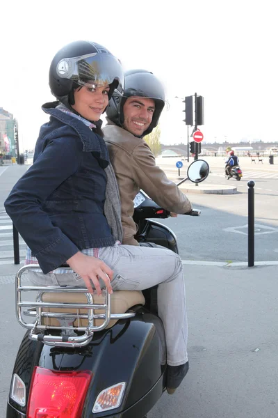 Um casal montando uma scooter — Fotografia de Stock