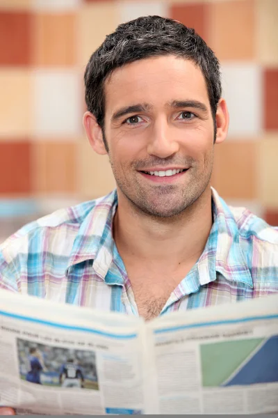 Lächelnder Mann beim Lesen einer Zeitung — Stockfoto