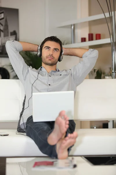 Los hombres escuchando música a través de un ordenador portátil —  Fotos de Stock