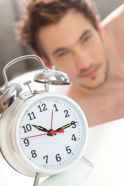 Ringing alarm clock waking up a man — Stock Photo, Image