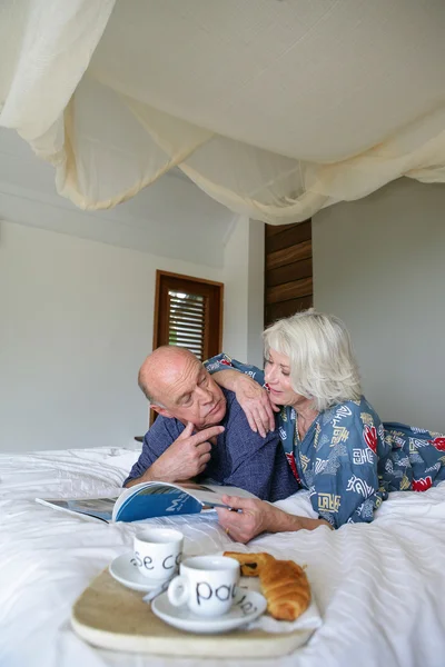 Idősebb pár, tekintettel a reggeli az ágyban — Stock Fotó