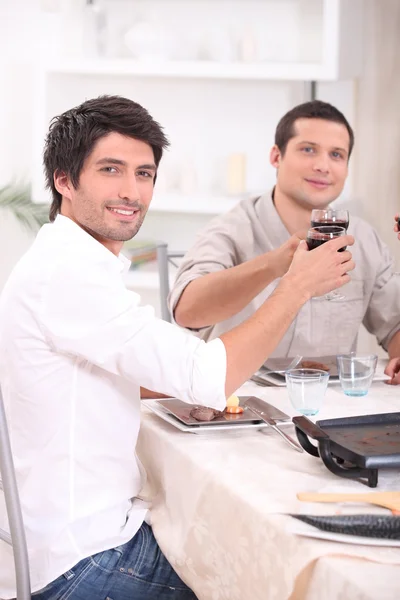 Männer klirren mit ihren Gläsern am Tisch — Stockfoto