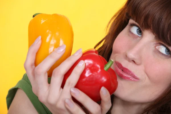 Kvinna med gul och röd paprika — Stockfoto