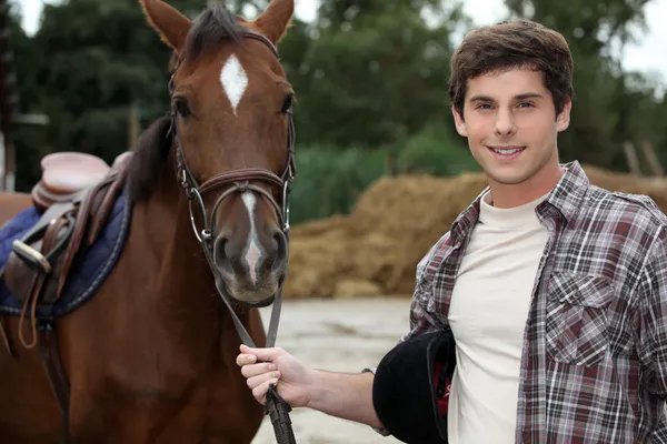 男子站立时由褐色的马 — 图库照片