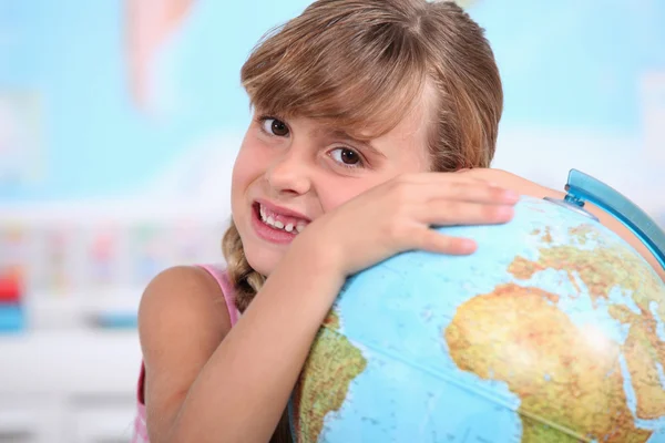年轻的女孩拥抱一个地球仪 — 图库照片