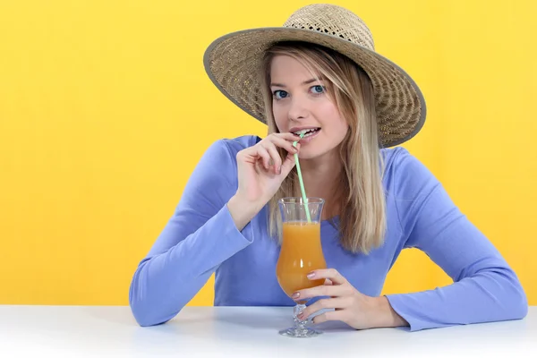 Женщина пьет сок через соломинку — стоковое фото