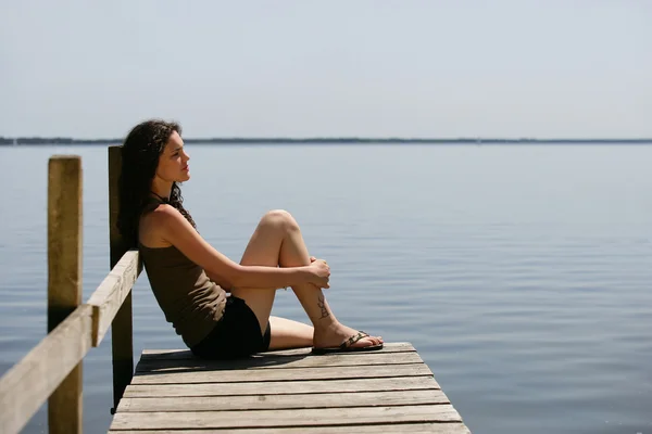 Vrouw zitten op een ponton — Stockfoto