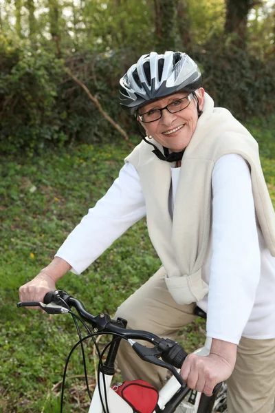 Starsza kobieta jazdy jej rower — Zdjęcie stockowe