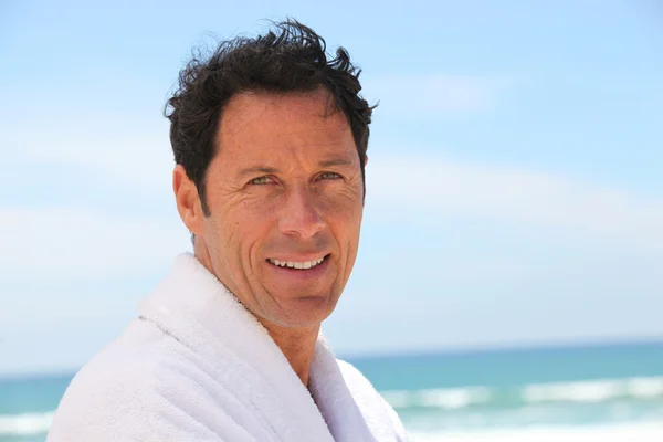 Man stond op het strand dragen badjas — Stockfoto