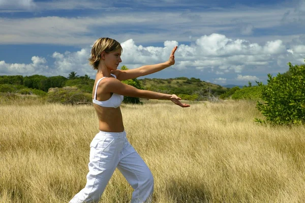 Frau macht Übungen auf einem Feld — Stockfoto