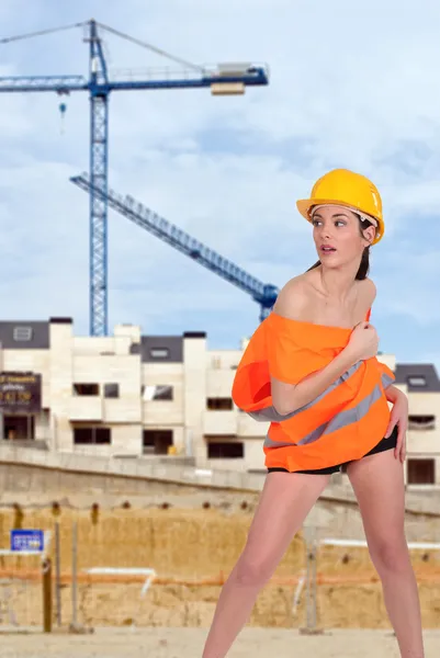 Hermosa mujer medio desnuda posando en un sitio de construcción — Foto de Stock