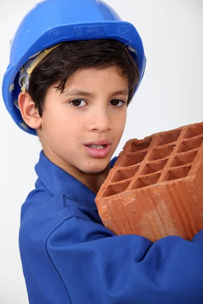 Little boy carrying brick — Stock Photo, Image