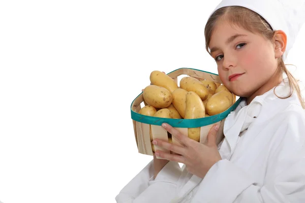 Little girl with a basket of new potatoes — Stock Photo, Image
