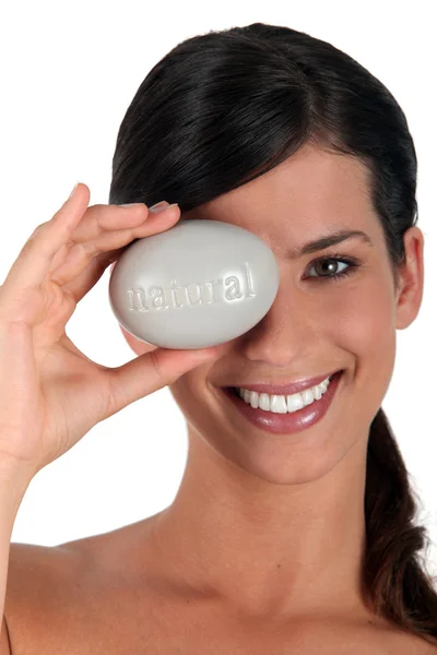 Woman covering eye with pebble marked natural — Stock Photo, Image