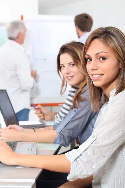 Young women smiling in classroom — Stock Photo, Image