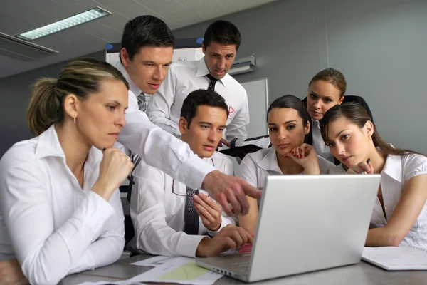 Reunião de equipe em volta de um computador portátil — Fotografia de Stock