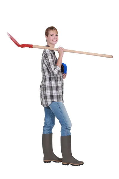 Hantverkerska innehar en spade på hennes axel — Stockfoto