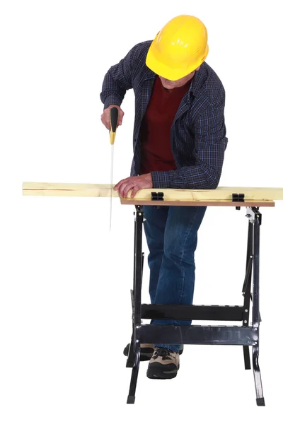 Man sawing plank of wood — Zdjęcie stockowe
