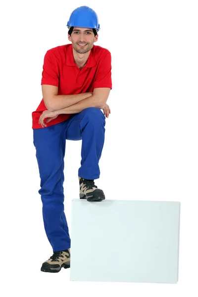 Craftsman leaning his foot on a blank box — Stock Photo, Image