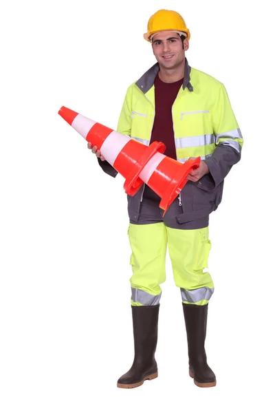 Дорожный рабочий держит дорожный конус — стоковое фото
