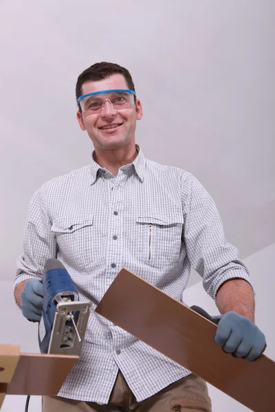 Usměvavá údržbář řezání prken — Stock fotografie
