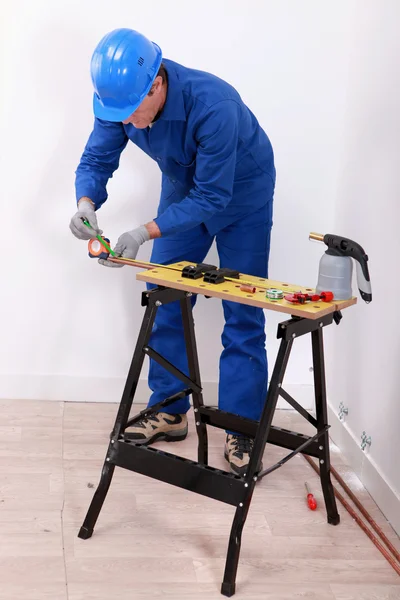 Un artesano trabajando en un tubo de cobre — Foto de Stock