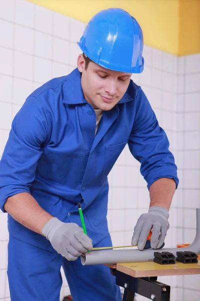 Young technician cutting a pipe — Stock Photo, Image