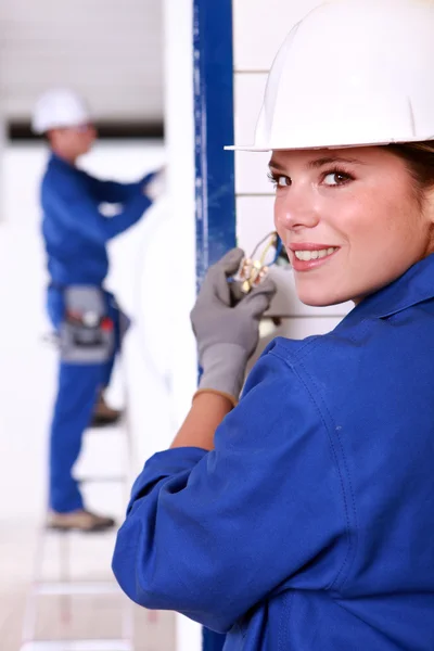 Kvinnlig elektriker installera en kraftkälla — Stockfoto