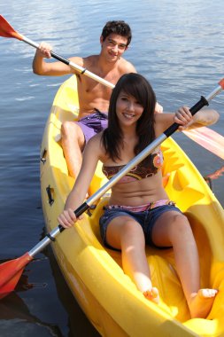 Young couple canoeing clipart