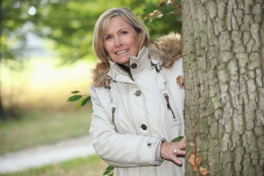 Woman out for an autumn stroll in the woods clipart