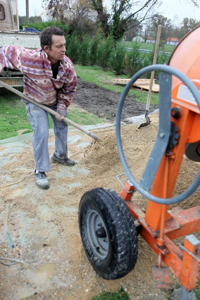 Labourer shovelling sand — Stock Photo, Image