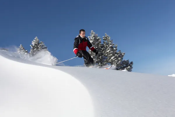 Человек катается на лыжах в заснеженной стране — стоковое фото