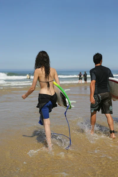 Pareja de jóvenes surfistas —  Fotos de Stock