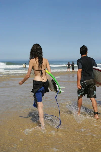 Pareja de jóvenes surfistas — Foto de Stock