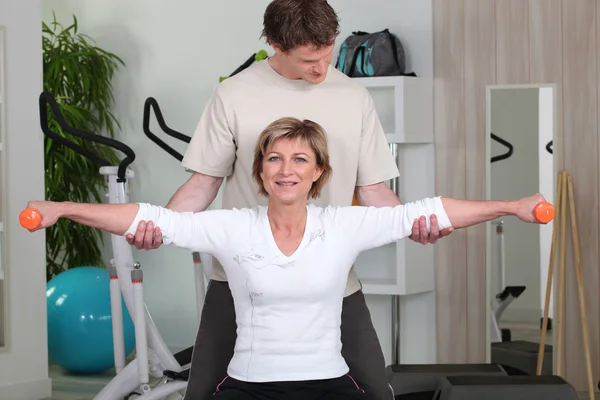 Osobní trenér pomáhá klientovi s její držení těla — Stock fotografie