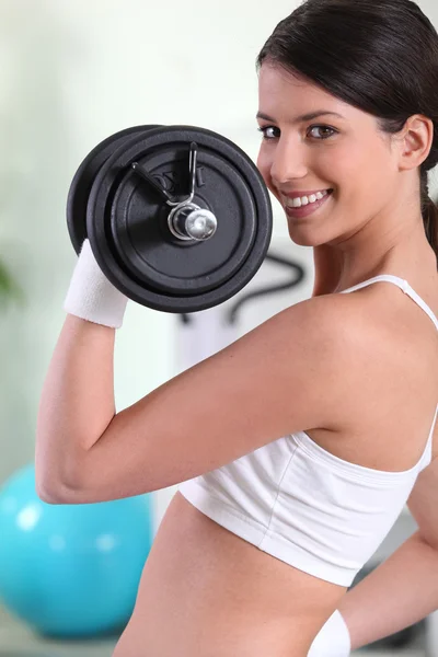 Femme soulevant du poids dans la salle de gym — Photo