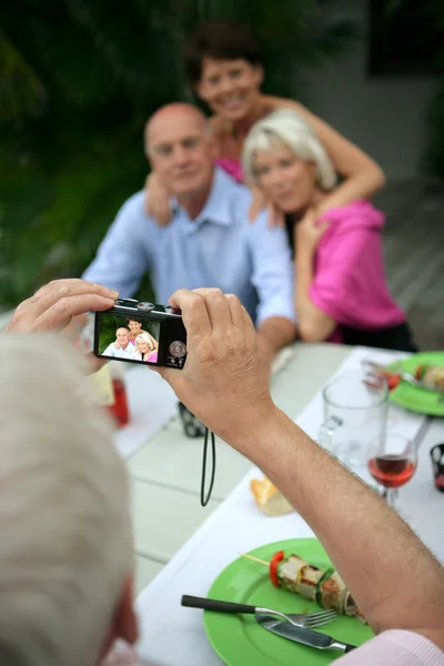 Senior groep glimlachend wordt gefotografeerd door een senior man — Stockfoto