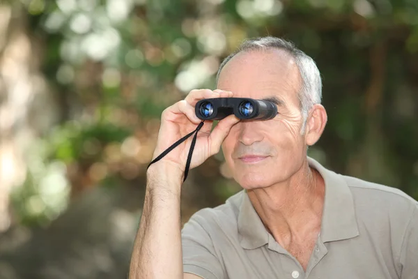 Hombre usando un par de prismáticos —  Fotos de Stock