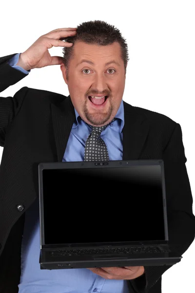 Hombre de negocios sorprendido sosteniendo una computadora portátil con una pantalla en blanco para y — Foto de Stock